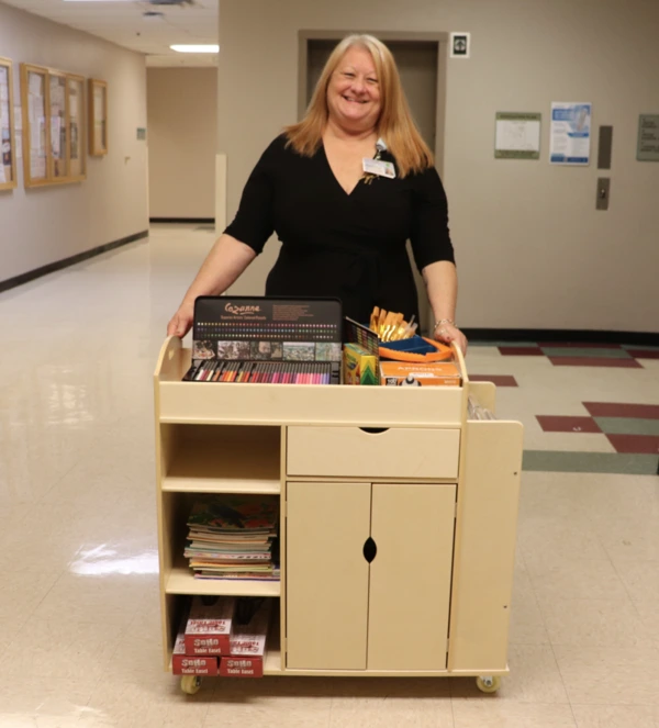 Kate Haygood, Annual Giving Manager, showcases the Art Cart and supplies, which were funded by a generous grant from the M. Stratton Foster Charitable Fund.