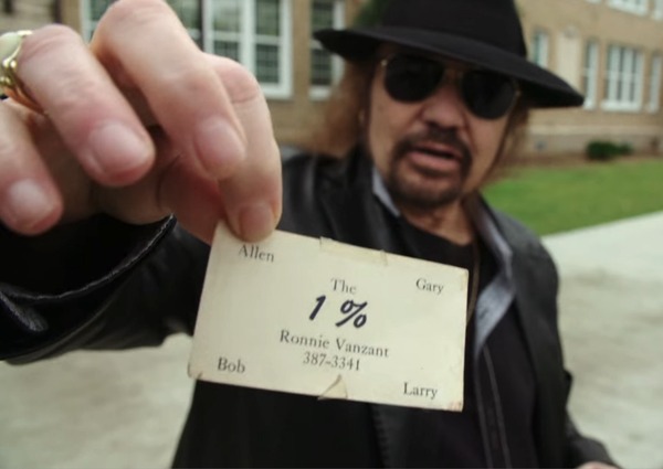 Gary Rossington holding the business card from the band, 1%