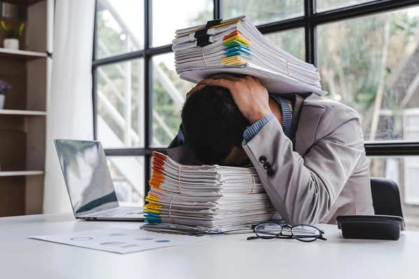 image of a man buried in paperwork