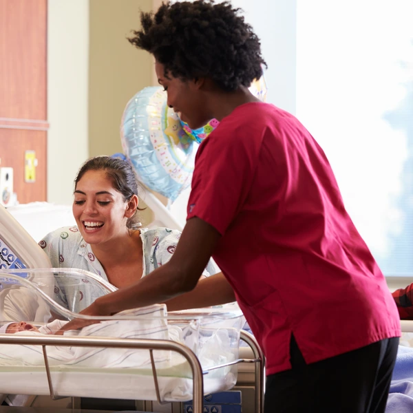 Nurse and mother with newborn in hospital